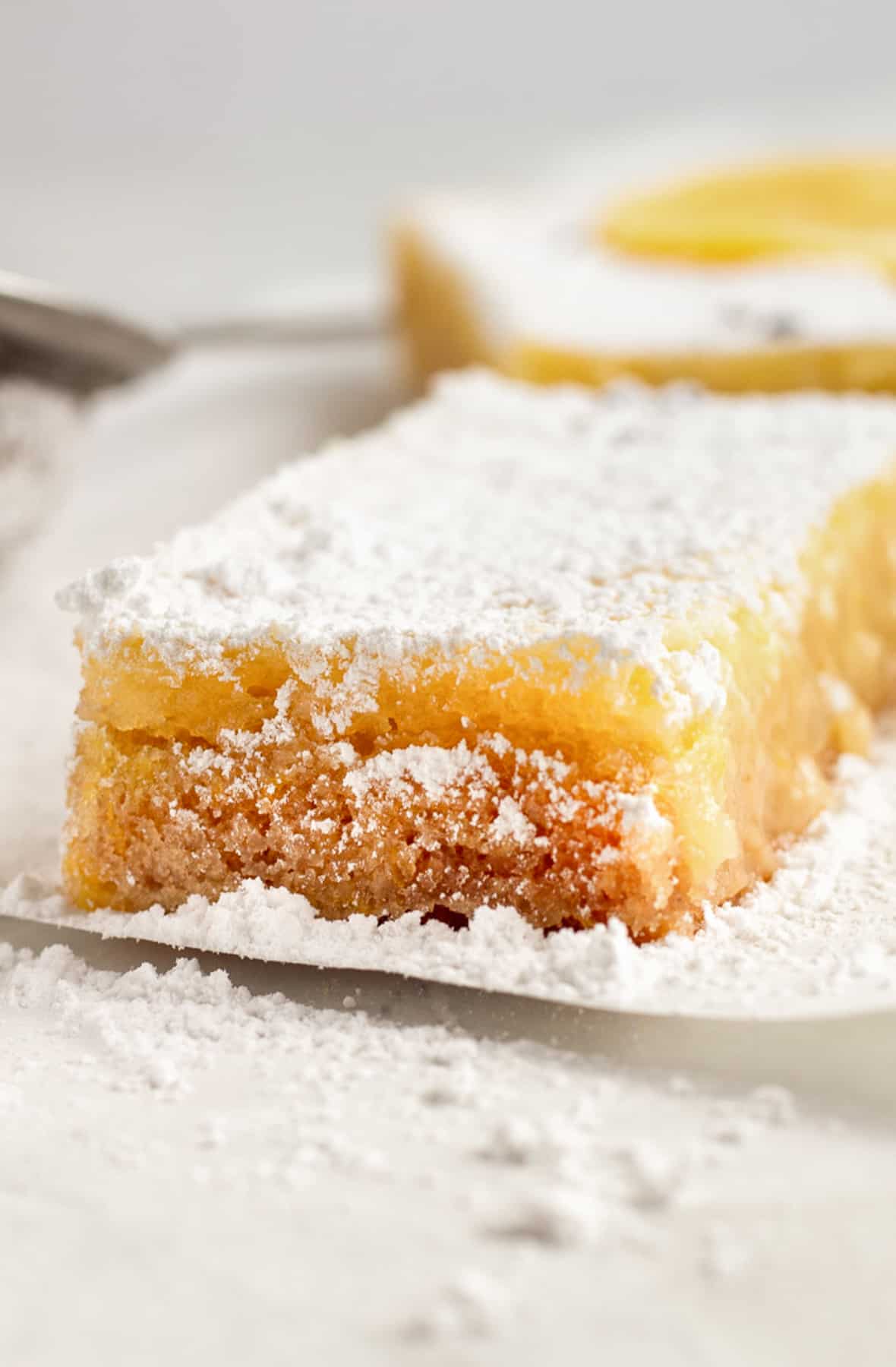slice of lavender lemon bar with crust, filling and sugar topping