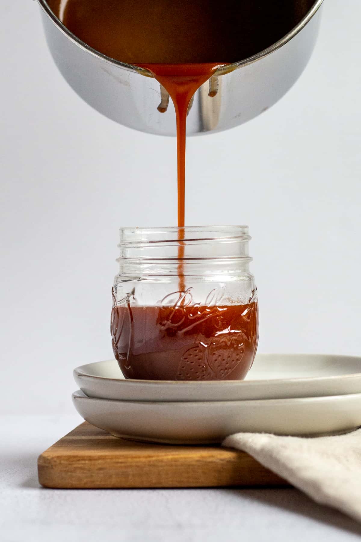 pouring salted caramel into a jar