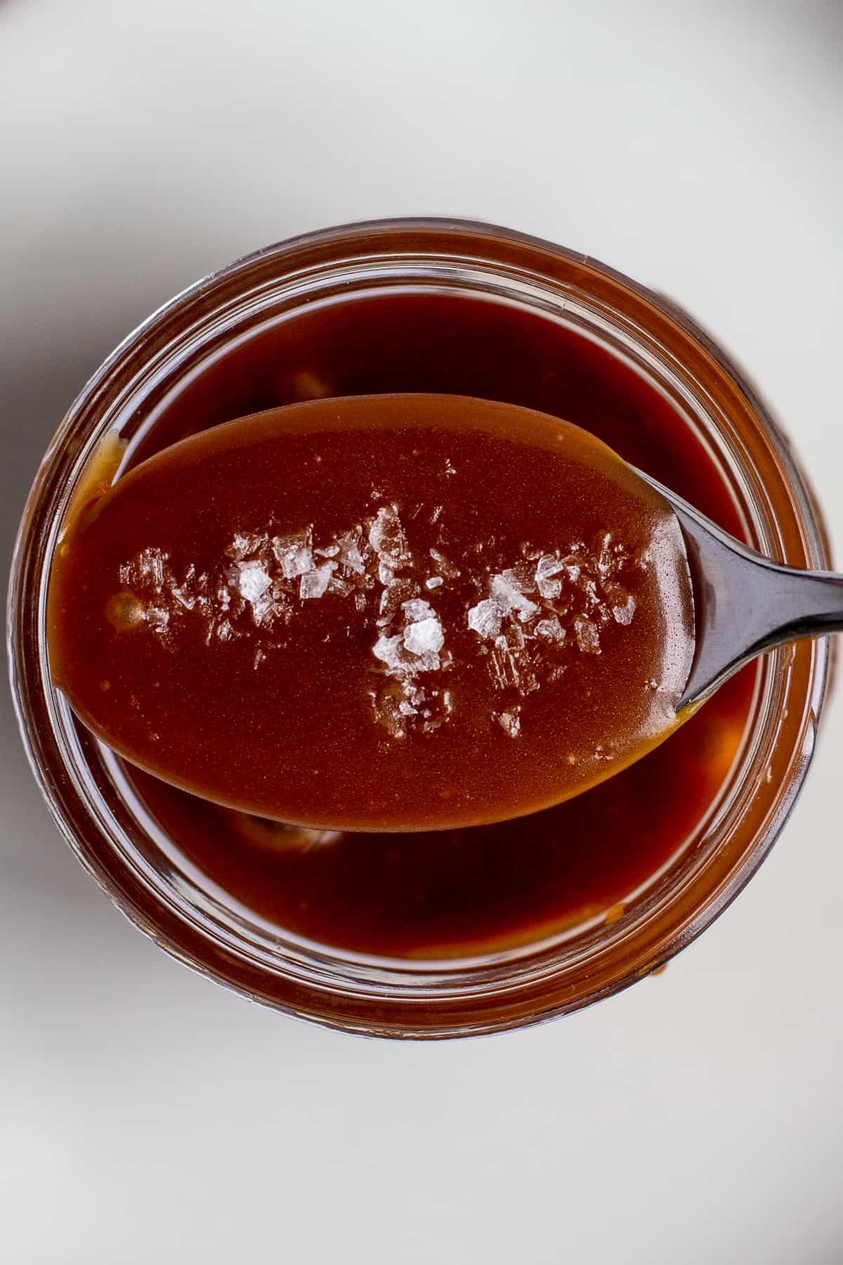 salted caramel on a spoon with flaky salt