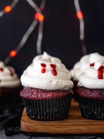 Halloween vampire bite red velvet cupcakes with vanilla ermine frosting lined up