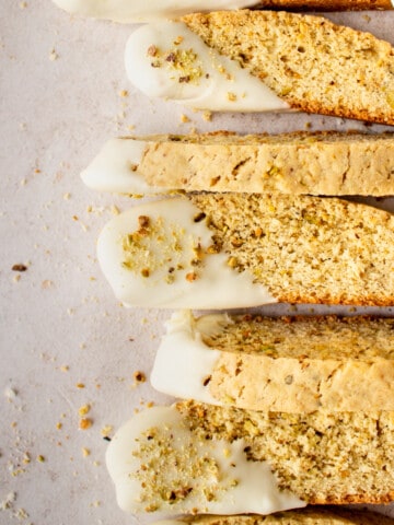 lemon biscotti lined up after being dipped in white chocolate