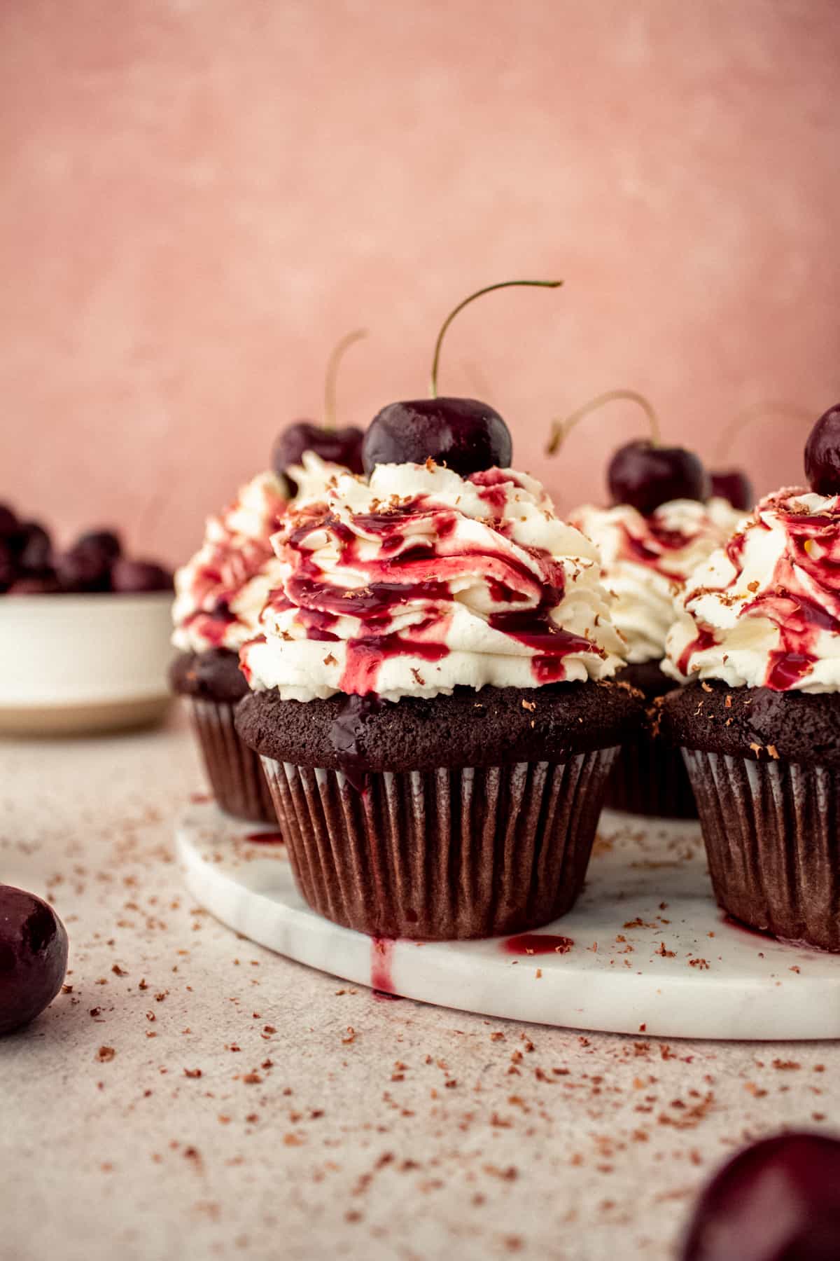 black forest cupcakes on platter with cherries and chocolate shavings