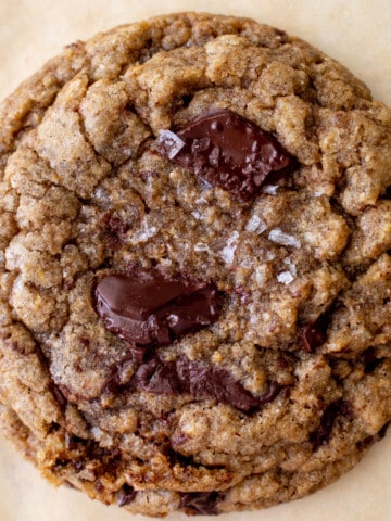close up image of one cookie with melty chocolate and flaky salt