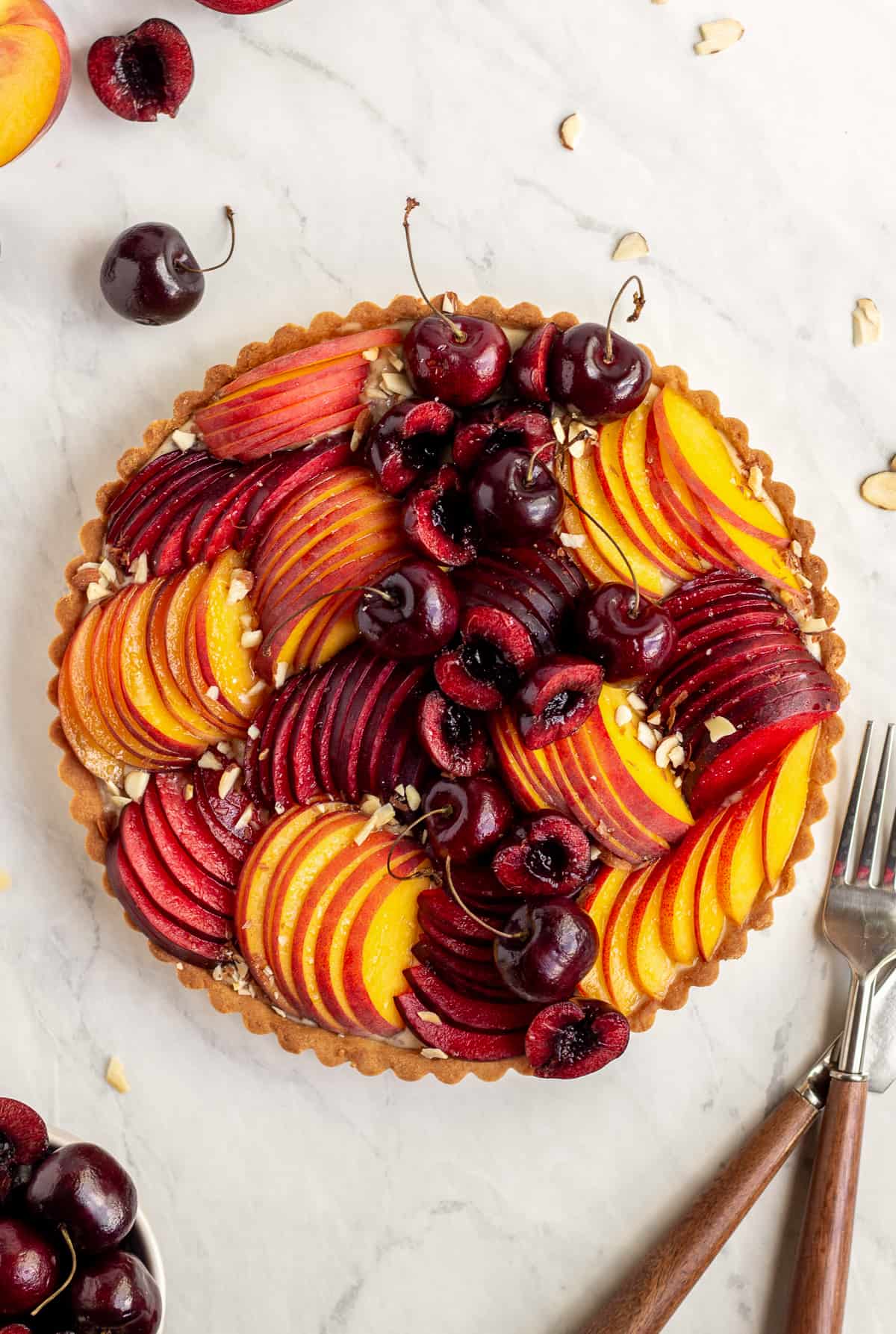 decorated tart with peaches, plums, and cherries 