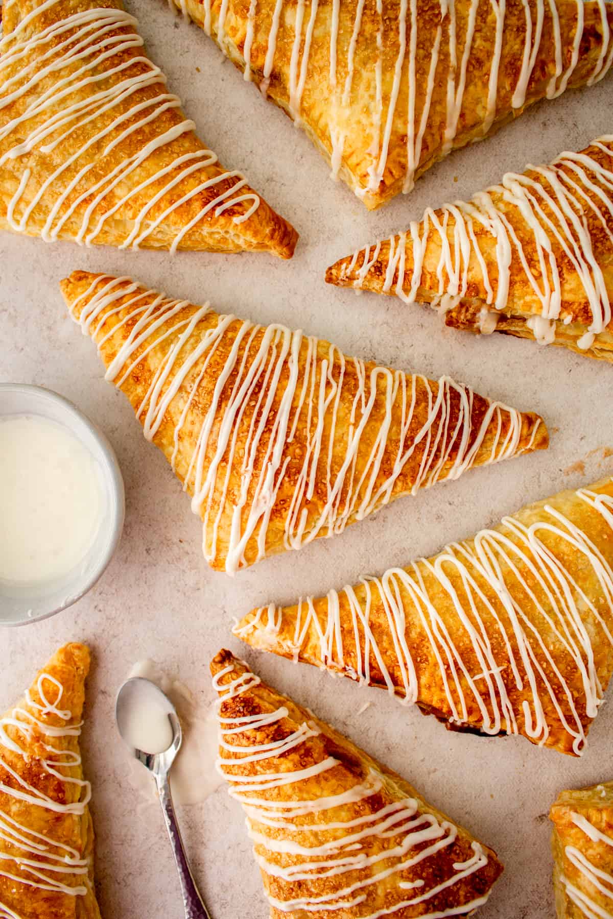 turnovers on cookie sheet with icing bowl