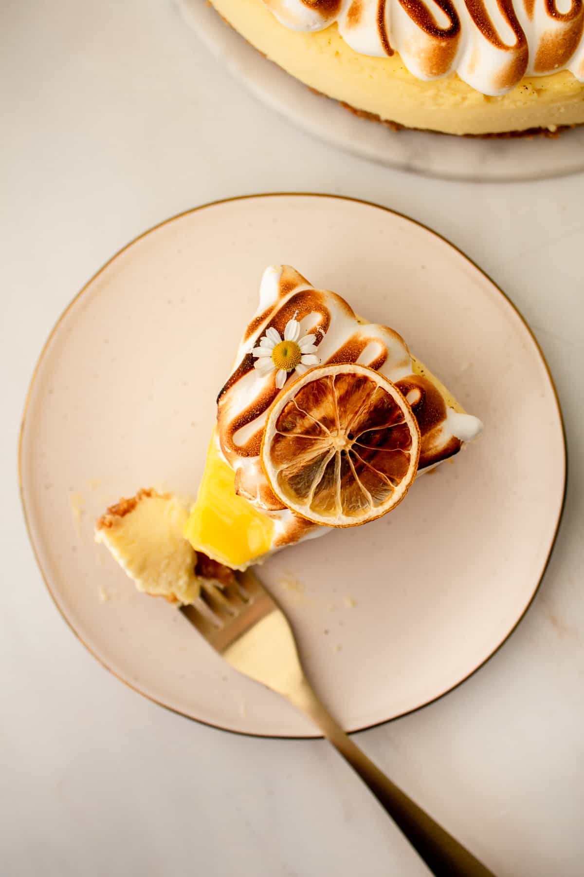 slice of lemon meringue cheese cake with a bite taken out